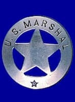A shiny silver pin stating U.S. Marshal