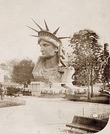 This is a black-and-white photo of the head and crown of the Statue of Liberty. It was on display in a park in Paris.