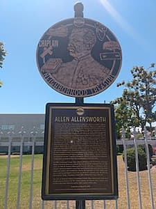 A roadside remembrance of Allen Allensworth and the town he founded. The top is a circular piece with a sketch of Allensworth; the bottom is a plaque explaining his achievements.