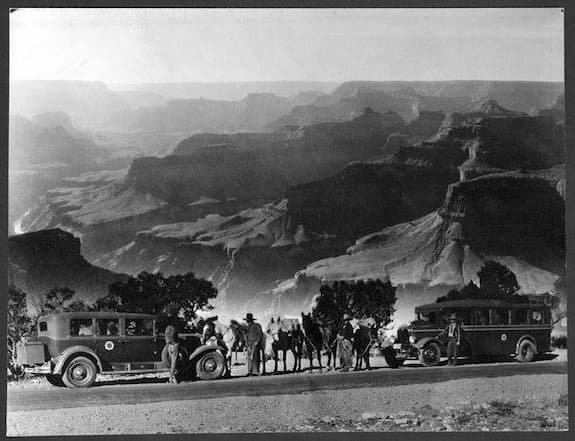 This photo depicts two cars for the Fred Harvey tourists. There seem to be 3 or 4 horses. The men have dismounted and are talking to the drivers.