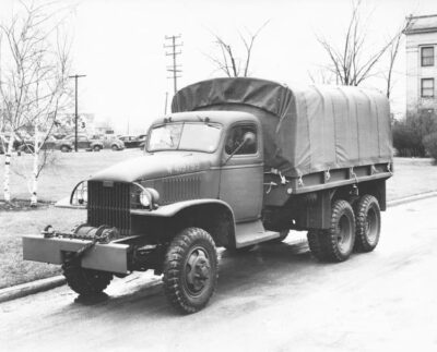 A photograph of a Jimmy with a canvas covered flatbed and traditional driving compartment.