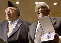Herman Johnson receives cross on behalf of his father