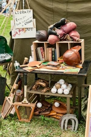 This is a color photograph of sports equipment (tennis racquets, boxing gloves, ping pong paddles, baseballs, etc.), perhaps available on an Army base. istockphoto