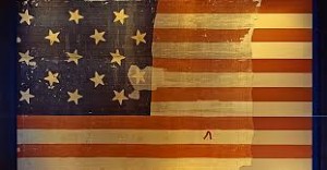A photograph of the restored Star Spangled Banner, currently on display at the Smithsonian.