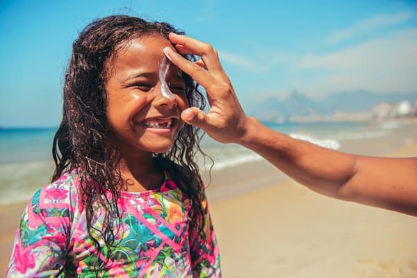 Applying sunscreen to a girl's face. istock image.