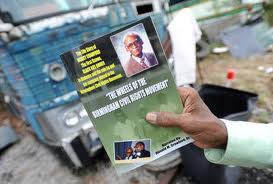 This is a color photograph of the book written by Donald Crawford, Sr. He holds the cover in front of one of his father's buses.