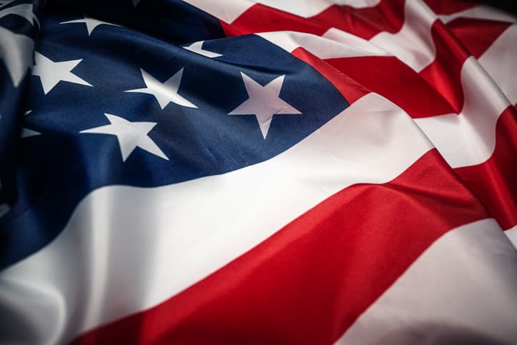 A color photograph of the American flag. It shows a few stars and some stripes, gathered as if waving.