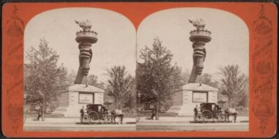 A stereopticon view of the arm and torch in Madison Square Garden. A horse and carriage is in the foreground. sepia colored