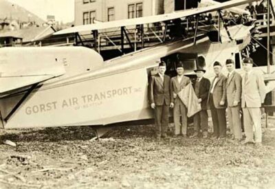 This is a photograph of Gorst Air Transport. Executives stand in front of the plane.