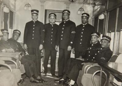 A black-and-white photo of a group of sleeping car porters. Lbrary of Congress. They are all in unifurm and looking at the camera.