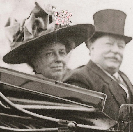 This is a black-and white photo of Helen Taft and President Taft out for a carriage ride. She is in a beautiful bonnet. He wears a top hat