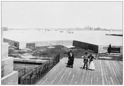 a black-and-white photo of people arriving on Bedloe Island in the 1890s. istockphoto. Credit ilbusca