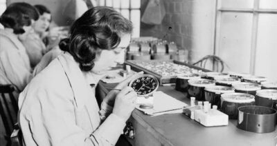 A black-and- white photo of young girls painting clock faces with paint laced with radium. wikimedia