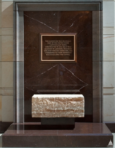 This plaque is displayed at the Capital Visitors Center. Below the plaque is a sandstone block saved from the original Capitol structure.
