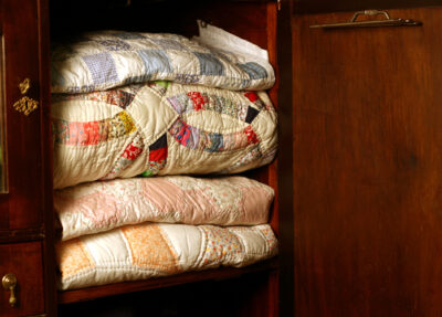 4 vintage quilts in a mahogany wardrobe