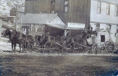 Black-and-white photo of a stagecoach traveling through a Montana town.