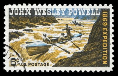 This is a U.S. postage stamp honoring John Weley Powell's exploration of the Grand Canyon by river travel. One boat is about to descend the rapids. Two more cna be seen in the distance.